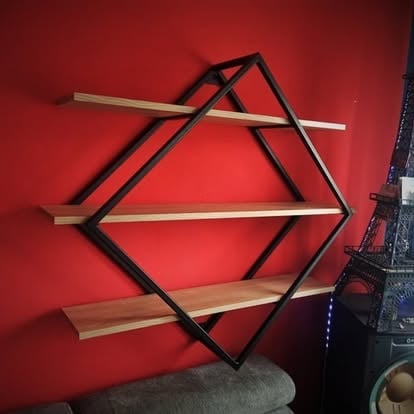 Geometryczny czarny metalowy półka-sześciokąt z drewnianymi półkami na czerwonej ścianie